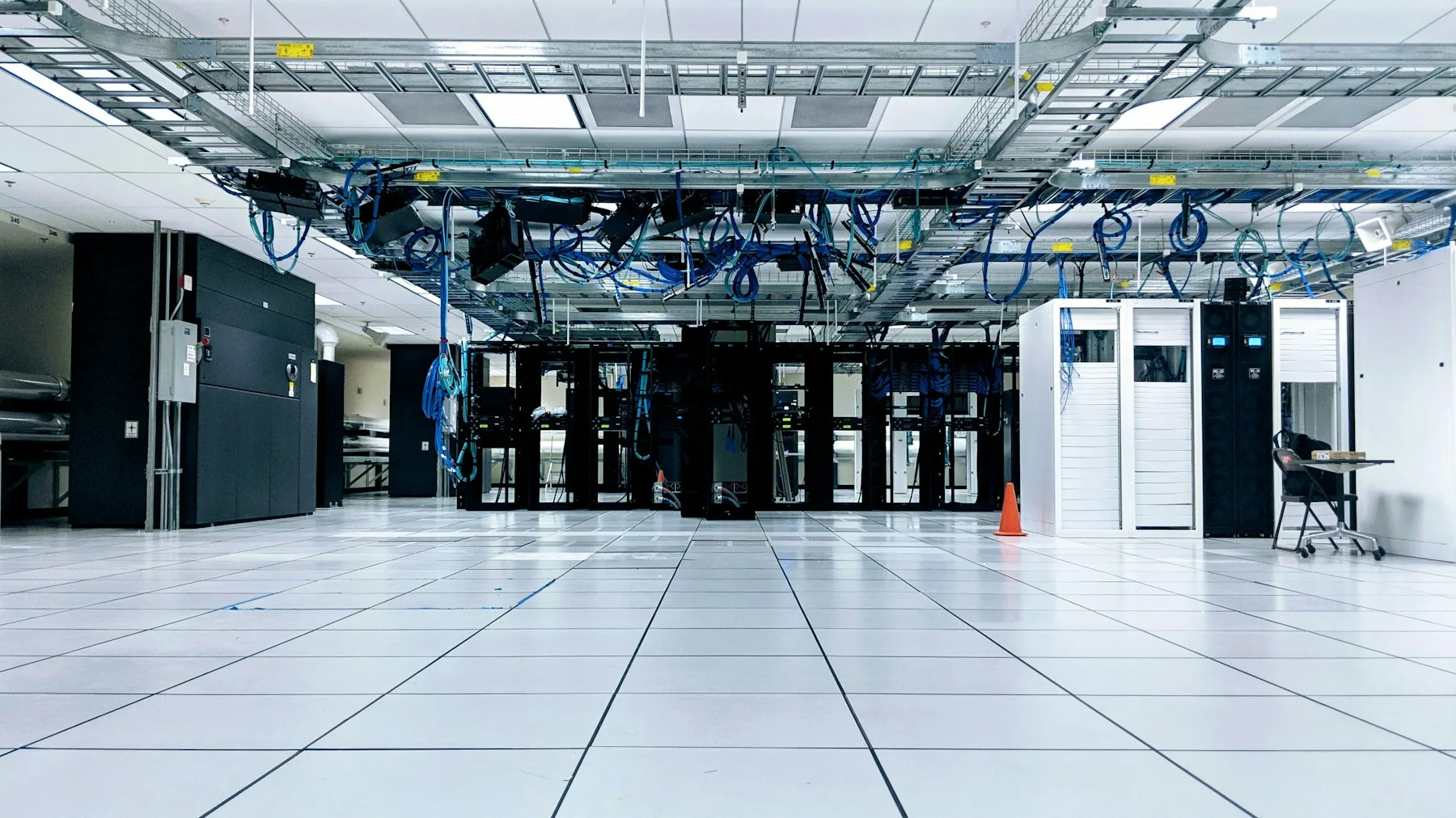 Server cabinets beneath rows of network cabling in a data centre